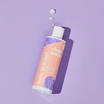 Top-down view of a leave-in curl cream bottle on a lavender surface featuring Asikue font in use