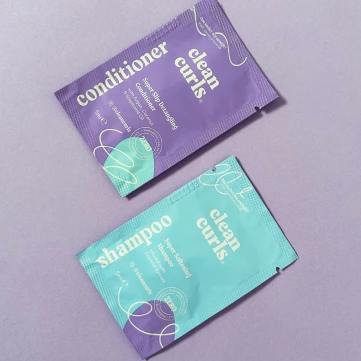 Two colorful mini sachets for shampoo and conditioner products featuring Asikue font in use
