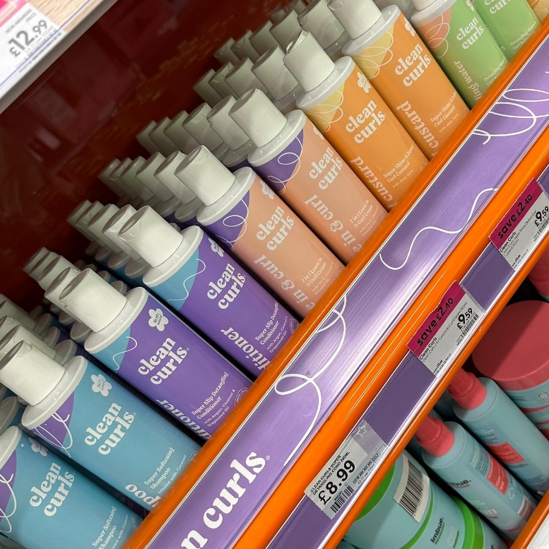Multiple bottles of hair care products lined up on a retail store shelf featuring Asikue font in use