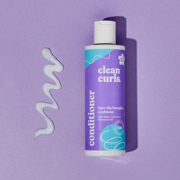 Top-down view of a leave-in curl cream bottle on a lavender surface featuring Asikue font in use